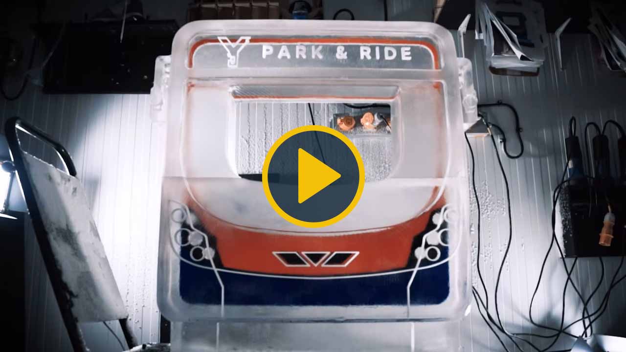 Still from First Bus video showing a bus ice sculpture with a play icon superimposed